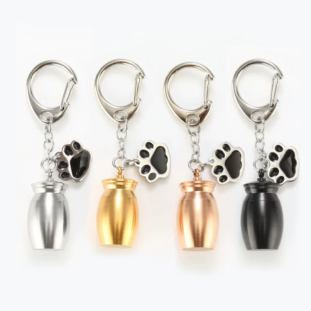 Pet memorial urn keychain with paw charm in silver, gold, rose gold, and black